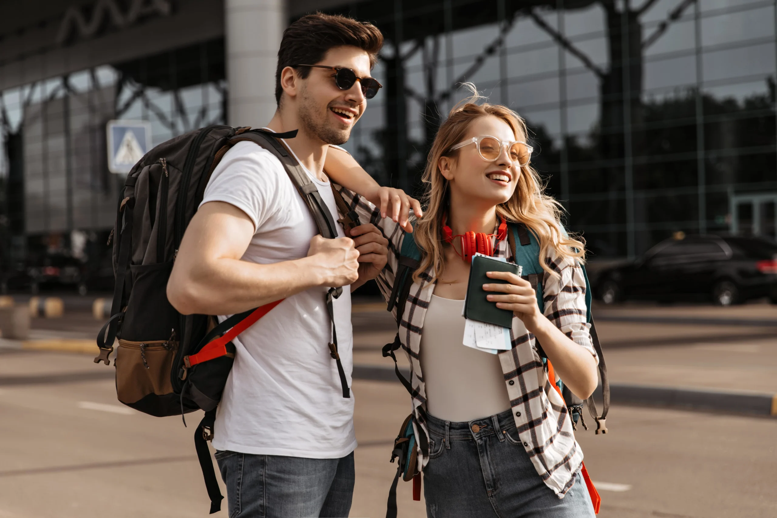 travelers-with-backpacks-poses-near-modern-airport-min
